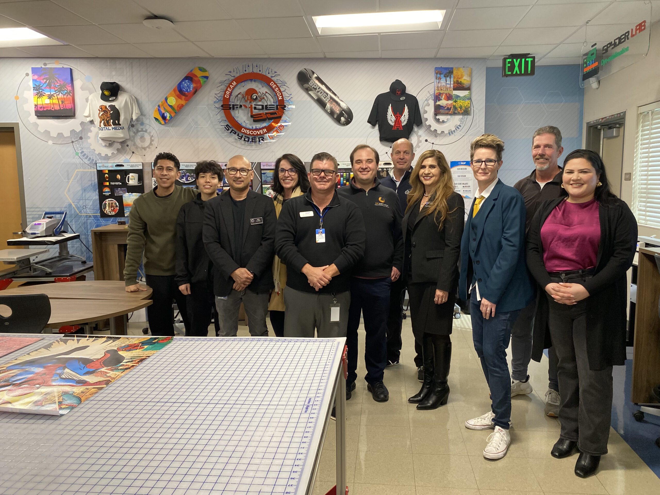 Michael Poirier poses with former students now employed by Spyder Lab, along with Dr. Kenneth Ko, Steven Kahn, Dr. Jacqueline Cardenas, Lauren Hartshorne, Jacquelyn Leyva and teachers from the ACCESS Century Day School site.