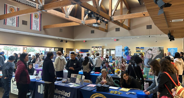 Attendees visit information booths and speak with agency representatives during last year’s countywide transition resource fair, held indoors at the IUSD Learning Center. Tables from community organizations line the room as families gather materials and ask questions about services and employment supports.