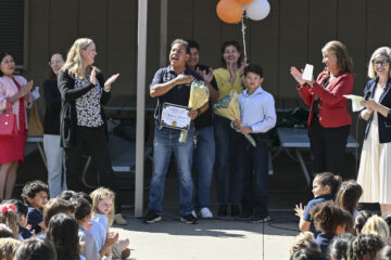Students gather in the quad at McPherson Magnet School on March 3 as Orange Unified School District and campus administrators surprise custodian Guillermo “Memo” Gutierrez after he is named the 2026 Orange County Classified School Employee of the Year in Custodial and Maintenance Services. His family stands behind him during the recognition.
