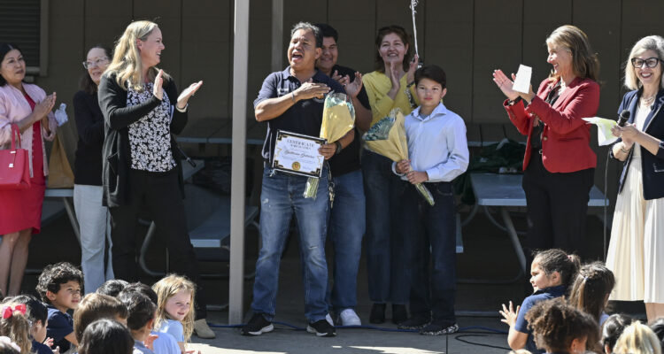 Students gather in the quad at McPherson Magnet School on March 3 as Orange Unified School District and campus administrators surprise custodian Guillermo “Memo” Gutierrez after he is named the 2026 Orange County Classified School Employee of the Year in Custodial and Maintenance Services. His family stands behind him during the recognition.