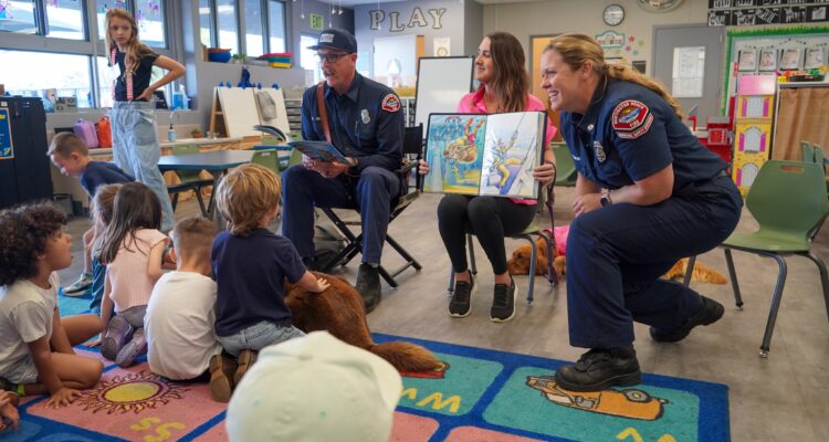 Huntington Beach Fire Department personnel read aloud in a classroom during Read Across America at Peterson Elementary School.