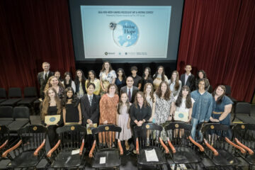 Student winners and their teachers gather on stage with Chapman University President Matt Parlow during the March 13 awards ceremony for the Sala and Aron Samueli Holocaust Art & Writing Contest.