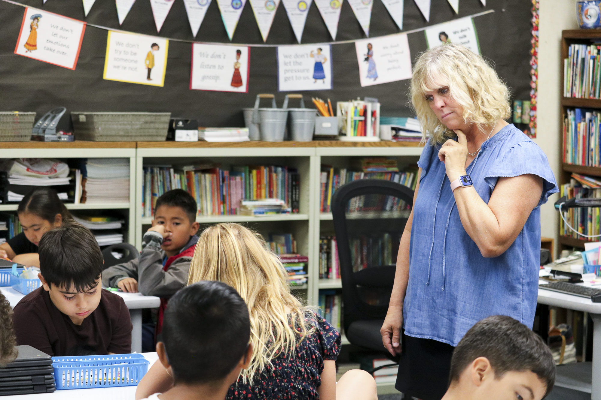 A teacher observes students working together in a classroom at a Saddleback Valley Unified School District school.
