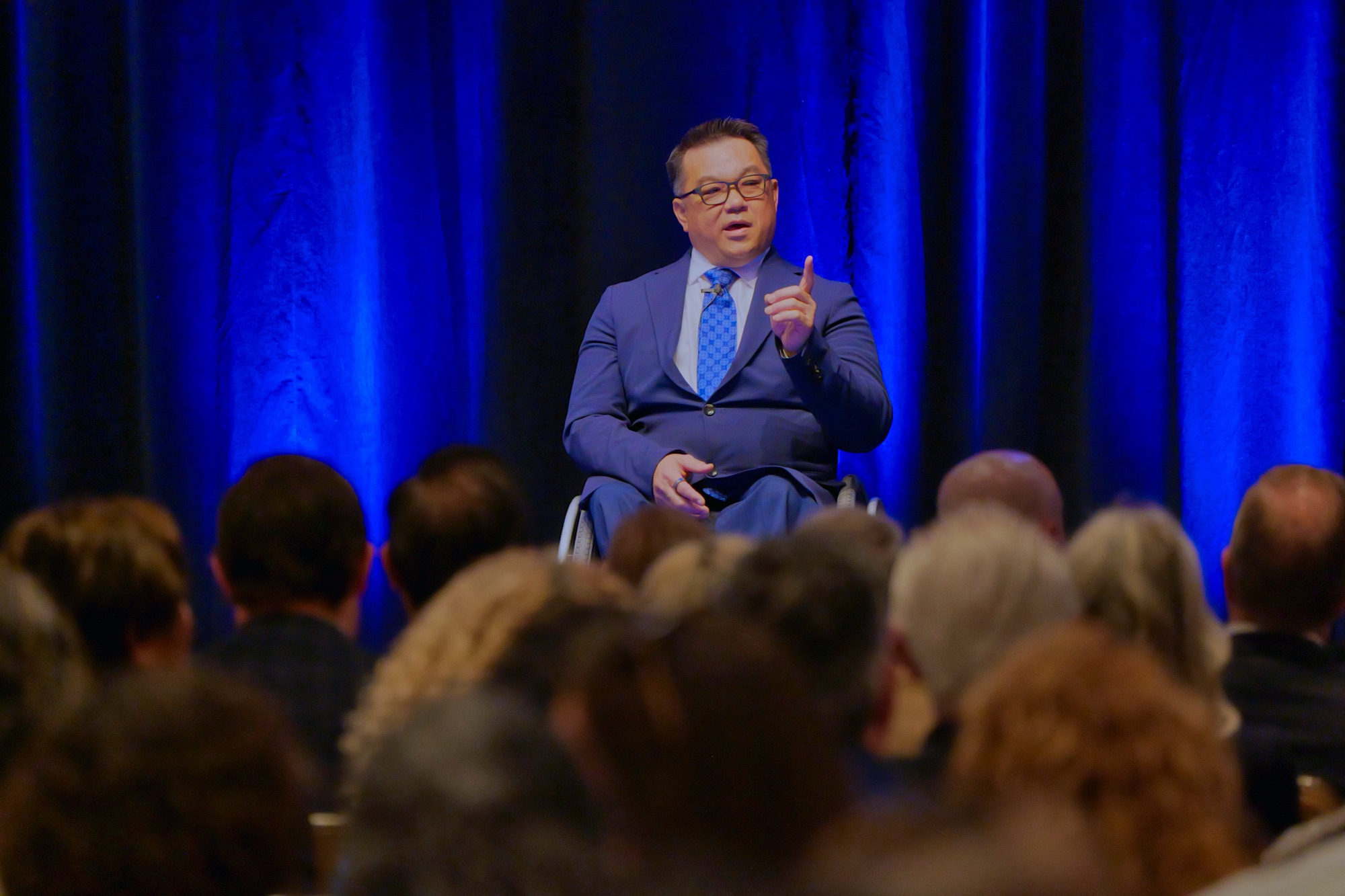 County Superintendent Dr. Stefan Bean speaks from the stage to a seated audience during the Orange County State of Education event