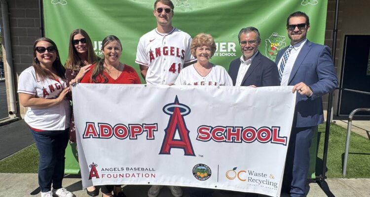 Trustee Alva Alvarez, Assistant Superintendent Dena Melland, Assistant Superintendent Dr. Yadira Moreno, Los Angeles Angels pitcher Jack Kochanowicz, Board President Jackie Filbeck, Superintendent Jesús Chavarria and Assistant Superintendent Matthew Slusser pose with an Angels Adopt-A-School banner at Gauer Elementary School in Anaheim.