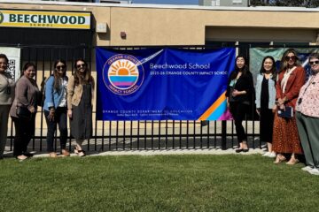 OCDE’s Impact Schools team joins Principal Hannah Lim beside Beechwood School’s banner recognizing its designation as an Impact School.