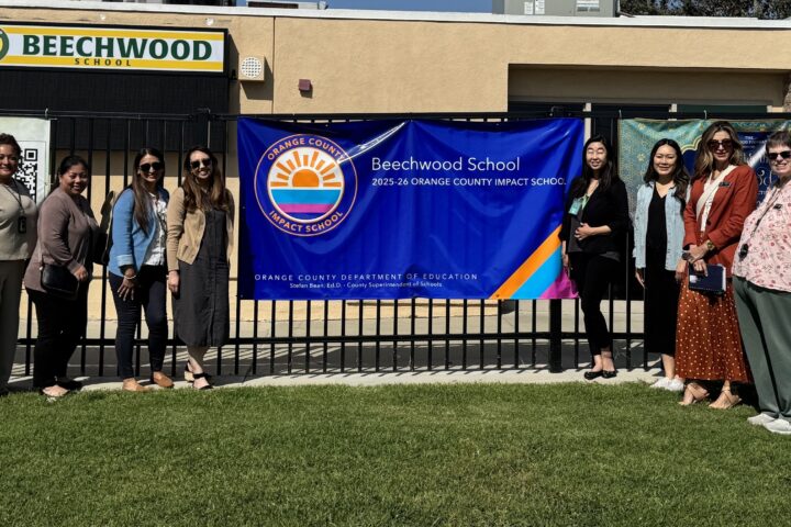 OCDE’s Impact Schools team joins Principal Hannah Lim beside Beechwood School’s banner recognizing its designation as an Impact School.