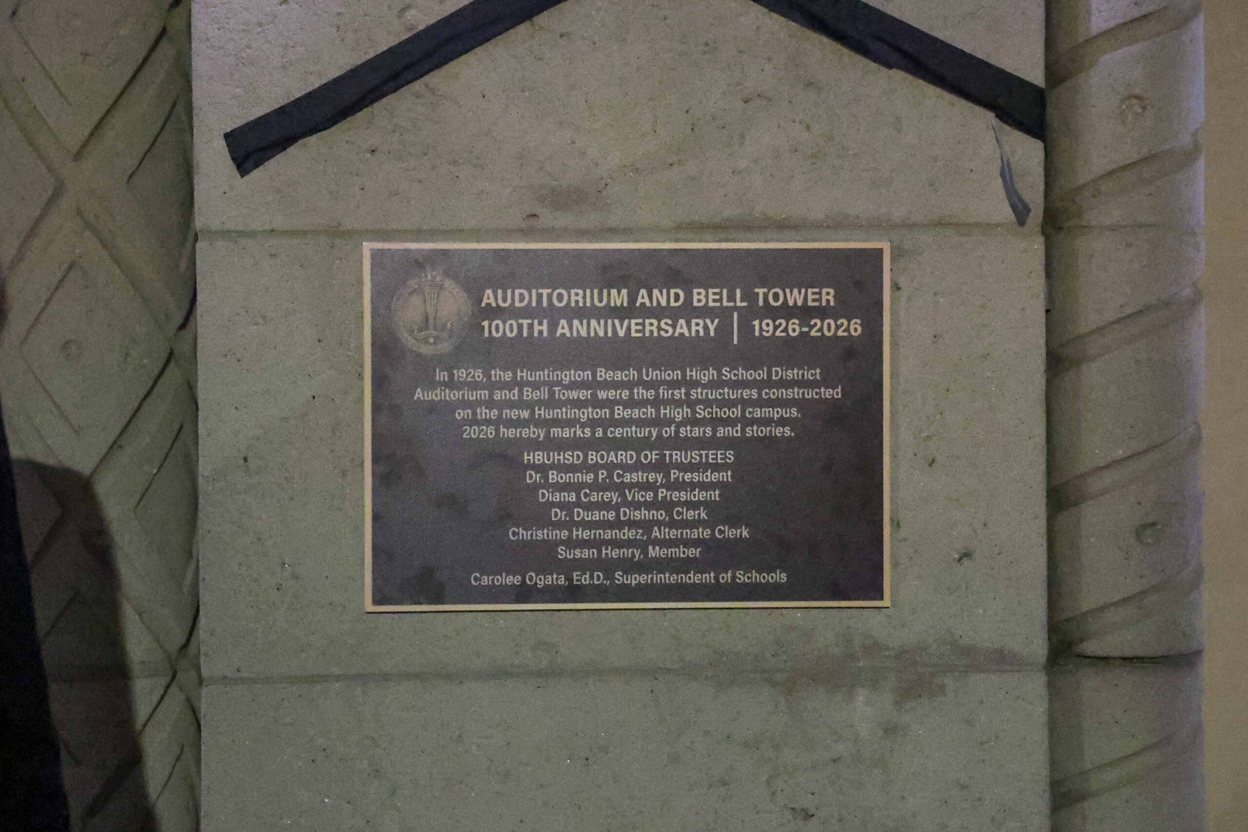 A commemorative plaque marks the 100th anniversary of the Huntington Beach Union High School District auditorium and bell tower, originally built in 1926.