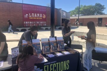 Representatives from the Orange County Registrar of Voters share voter registration information with students at Loara High School in the Anaheim Union High School District on March 12.