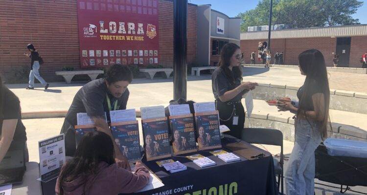 Representatives from the Orange County Registrar of Voters share voter registration information with students at Loara High School in the Anaheim Union High School District on March 12.