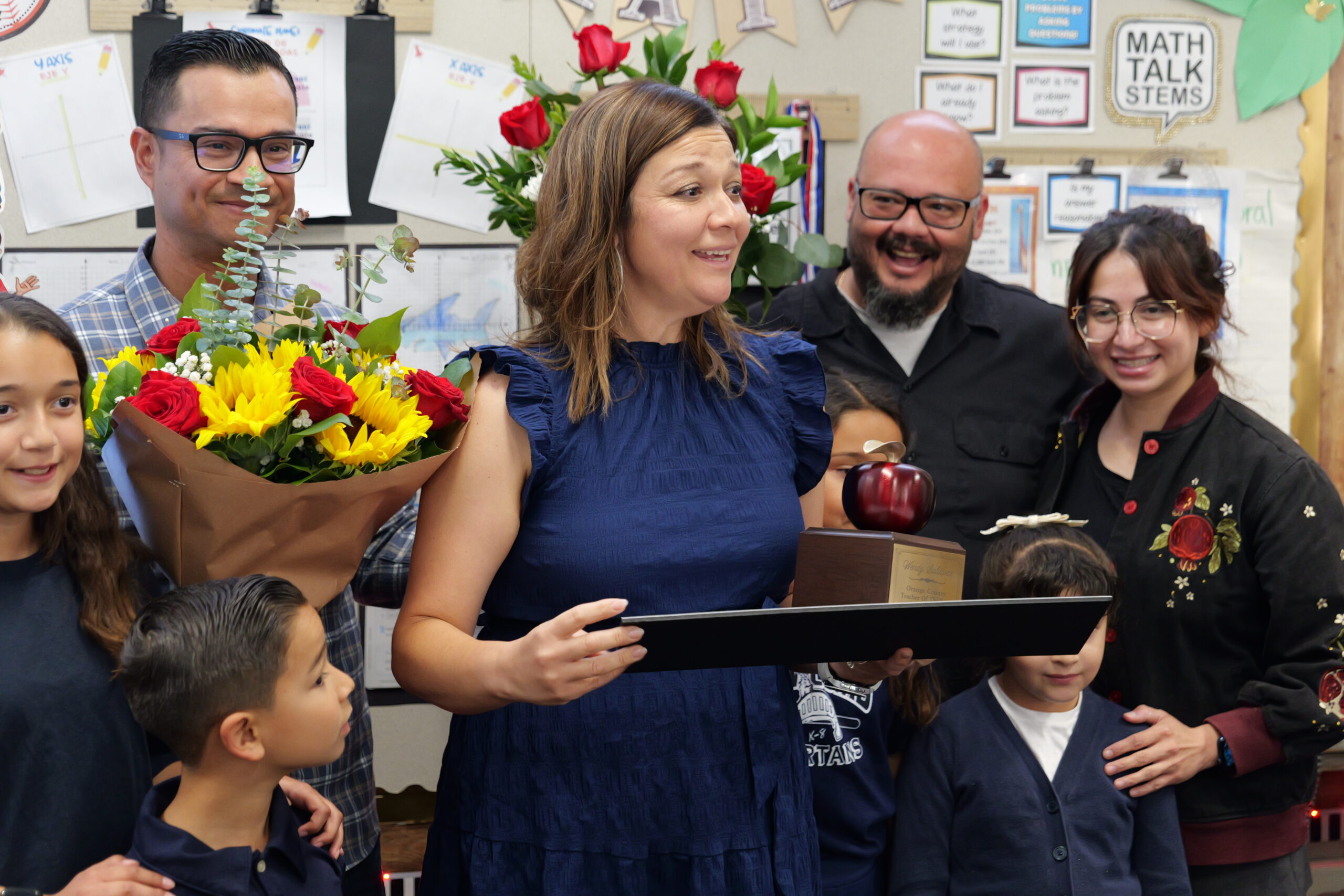 Loara Elementary School teacher Wendy Saldivar receives flowers and congratulations from her family as she learns of her 2027 Orange County Teacher of the Year status.