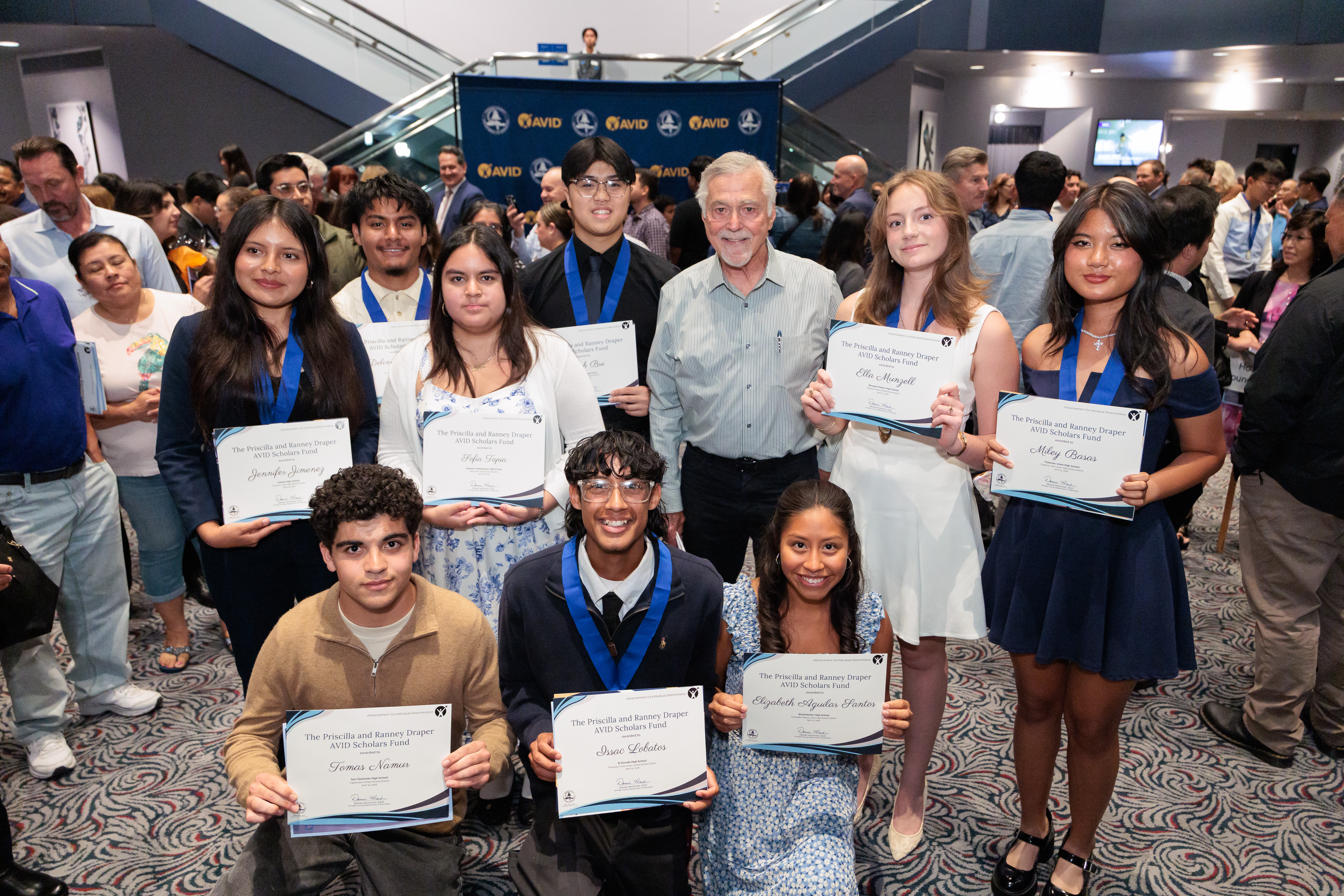 AVID seniors pose with scholarships from the Priscilla and Ranney Draper AVID Scholars Fund during the 2026 OC AVID Senior Standout Recognition and Scholarship Presentation at the Irvine Barclay Theatre.