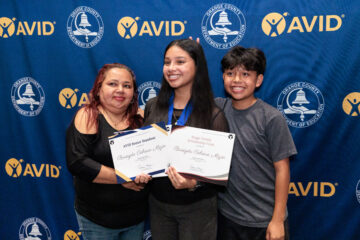 Briseyda Cabrera Mejia of Estancia High School poses with family members after being recognized as a 2026 AVID Senior Standout.