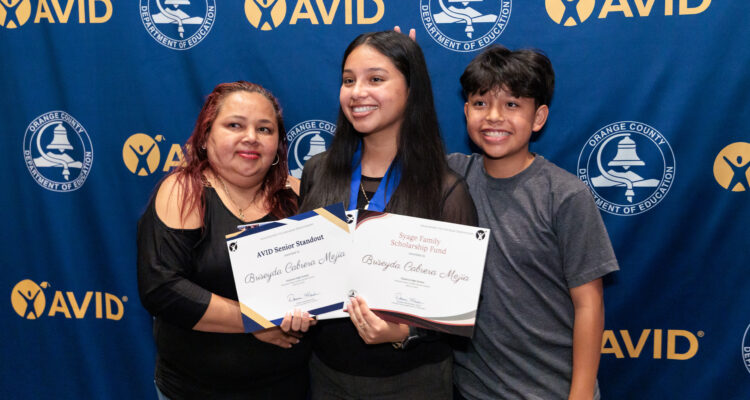 Briseyda Cabrera Mejia of Estancia High School poses with family members after being recognized as a 2026 AVID Senior Standout.