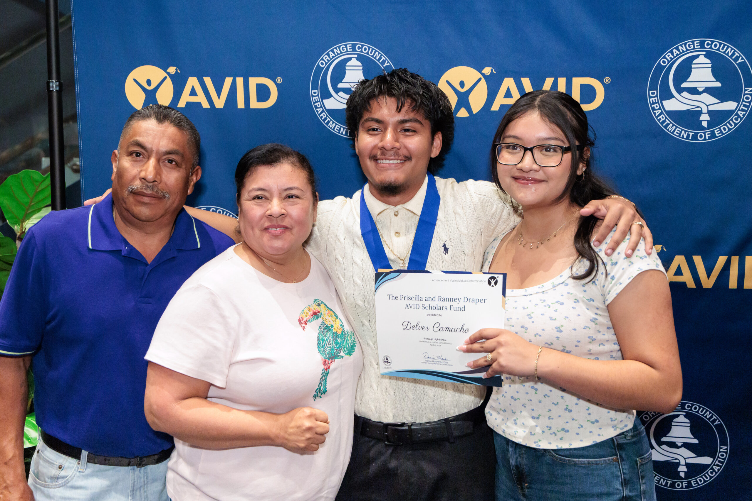 Delver Camacho of Santiago High School poses with family after receiving a scholarship during the 2026 OC AVID Senior Standout Recognition and Scholarship Presentation.