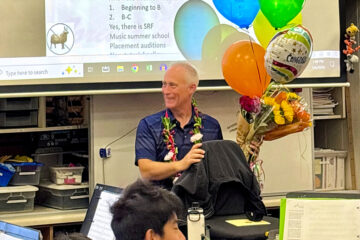 Henry Miller sits in his Sierra Vista Middle School music classroom surrounded by students and colorful congratulatory balloons after being named a 2027 CMA Foundation Music Teacher of Excellence.