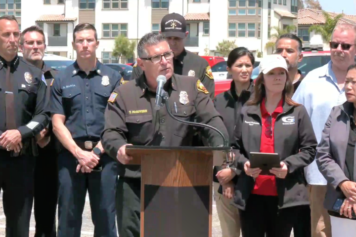 Orange County Fire Authority Interim Fire Chief T.J. McGovern speaks at a podium during a news conference surrounded by fire, law enforcement and public health officials responding to the Garden Grove chemical leak emergency.