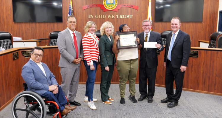 Connections student Savannah accepts her award alongside members of the Orange County Board of Education and Superintendent Dr. Stefan Bean.