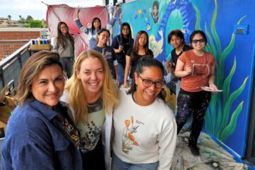Painters from Warner Middle School and Westminster High School pose for a photo while working on a mural depicting the ecosystems of the Bolsa Chica Wetlands.