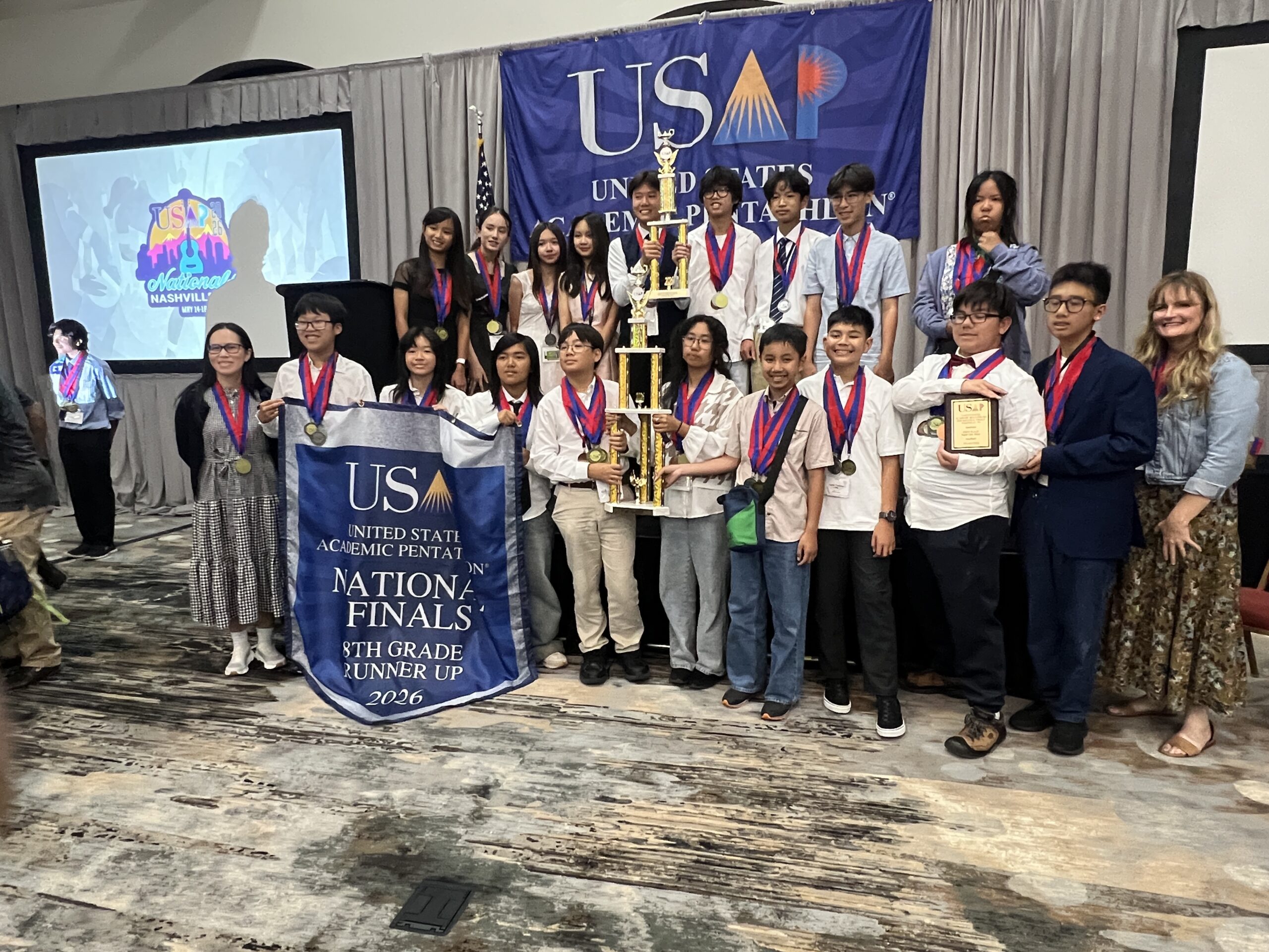 Students from McGarvin Intermediate School pose with medals and trophies during an awards ceremony at the 2026 United States Academic Pentathlon National Finals in Nashville, Tennessee.