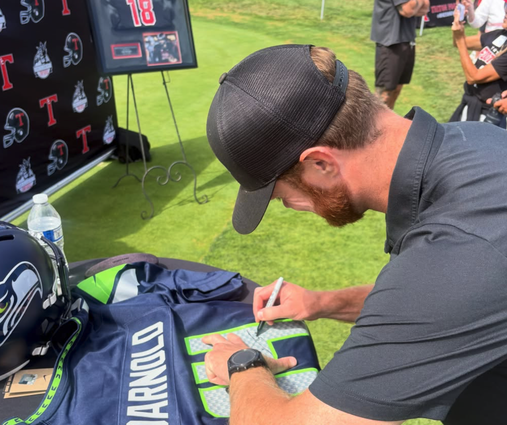 Sam Darnold signing some Seattle Seahawks gear at the Triton Hall of Fame Golf Tournament at the Talega Golf Course in San Clemente.
