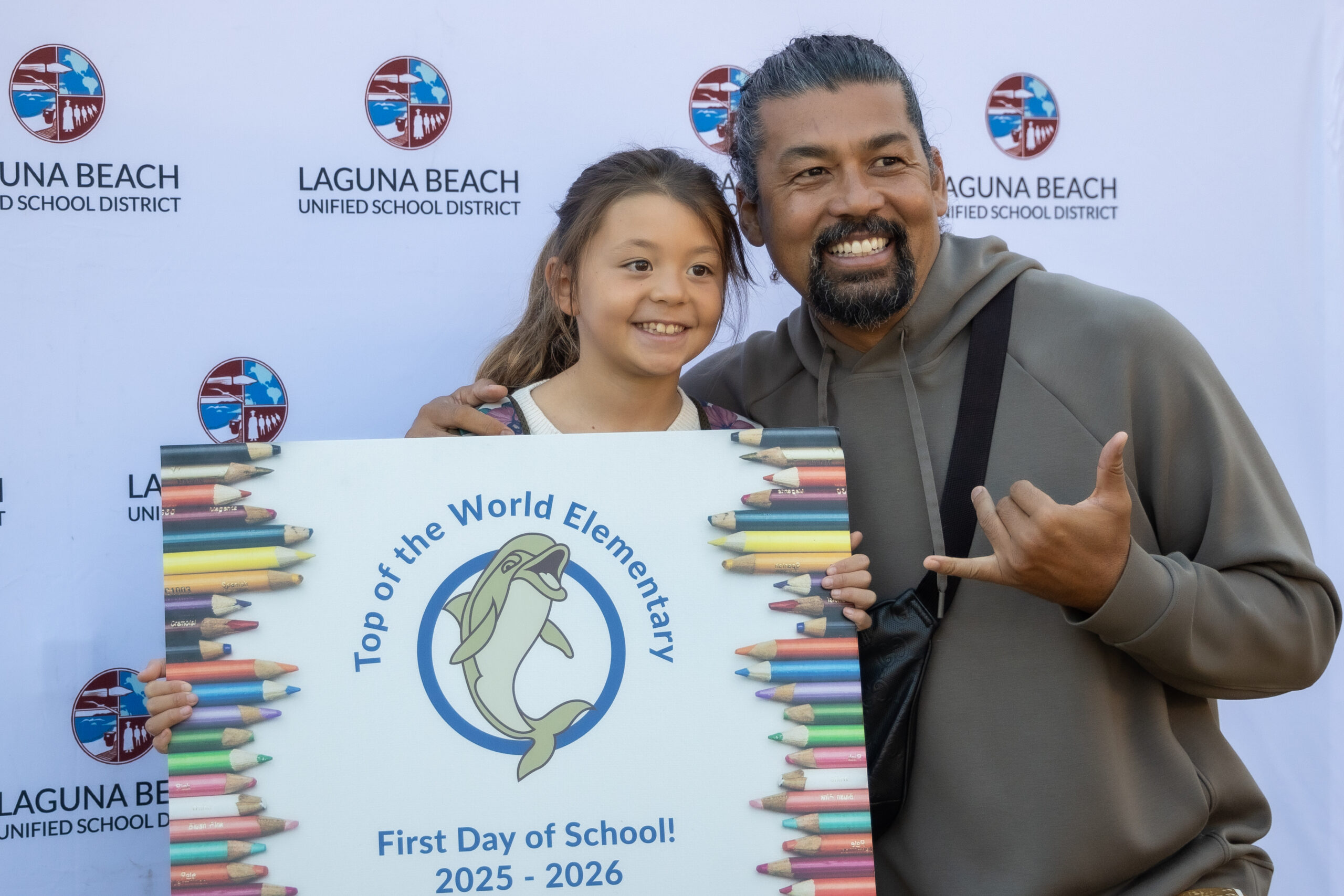 A student and an adult family member pose with a first-day-of-school photo frame at Top of the World Elementary School in the Laguna Beach Unified School District.