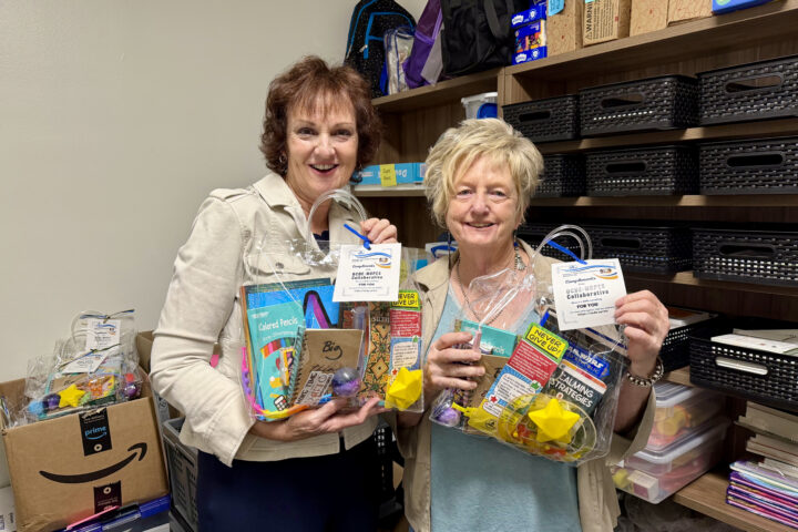 OCDE Student Programs and Services Coordinator Jeanne Awrey, left, and Senior Administrative Assistant Terri Glover hold welcome gifts prepared for children and youth staying in local homeless shelters. The gifts include school supplies, books and other items selected for students of different ages.