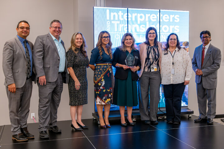 OCDE leaders and staff surprise Language Services Coordinator Natalia Abarca, center, with a Visionary Leadership Award in recognition of her work advancing language access in education.