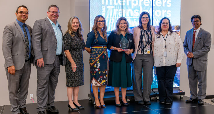 OCDE leaders and staff surprise Language Services Coordinator Natalia Abarca, center, with a Visionary Leadership Award in recognition of her work advancing language access in education.