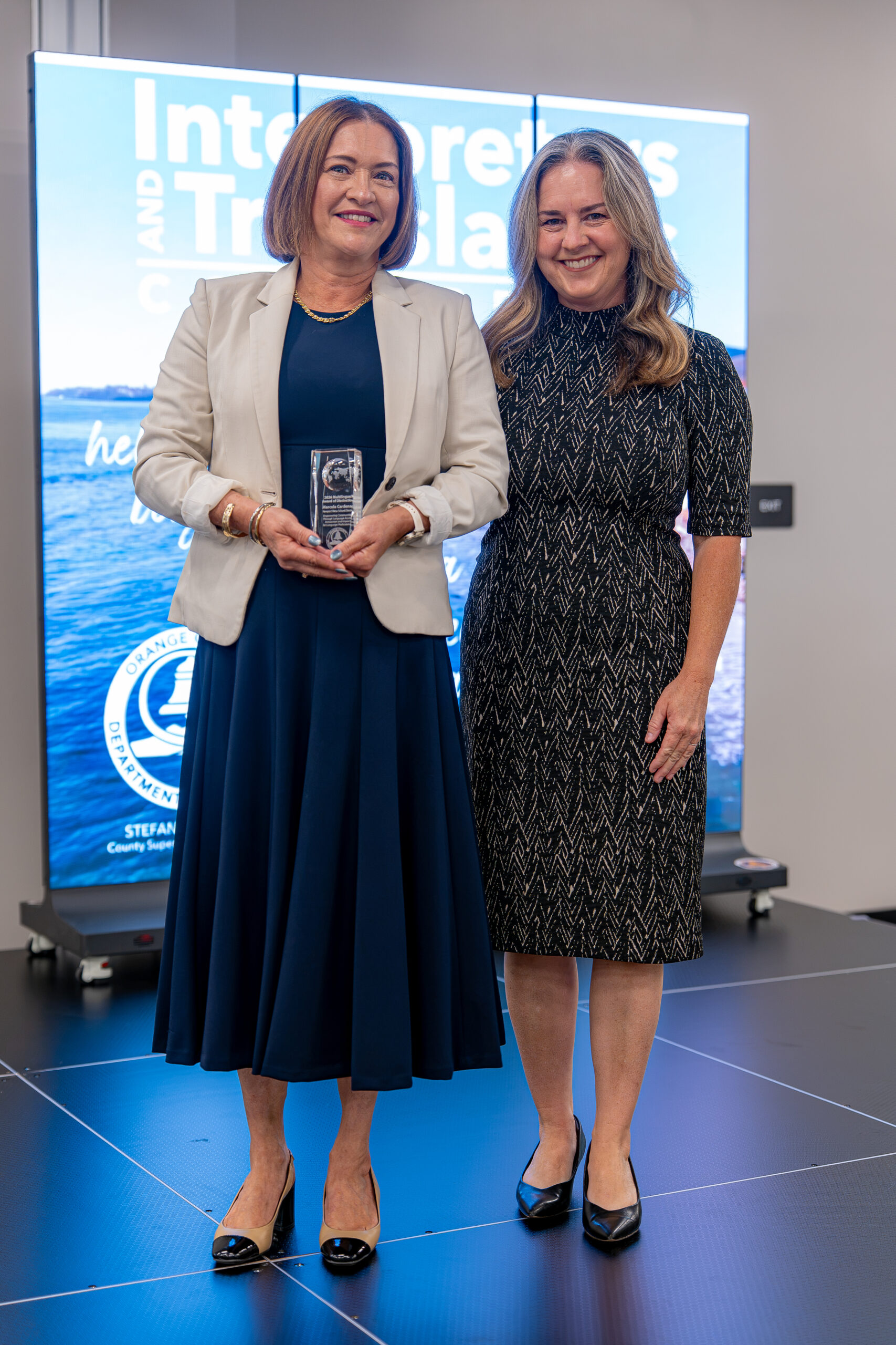 Marcela Cardenas of the Newport-Mesa Unified School District, left, receives a 2026 Multilingual Award of Distinction alongside Stacy Deeble-Reynolds, OCDE executive director of Student Initiatives, Partnerships and Events.