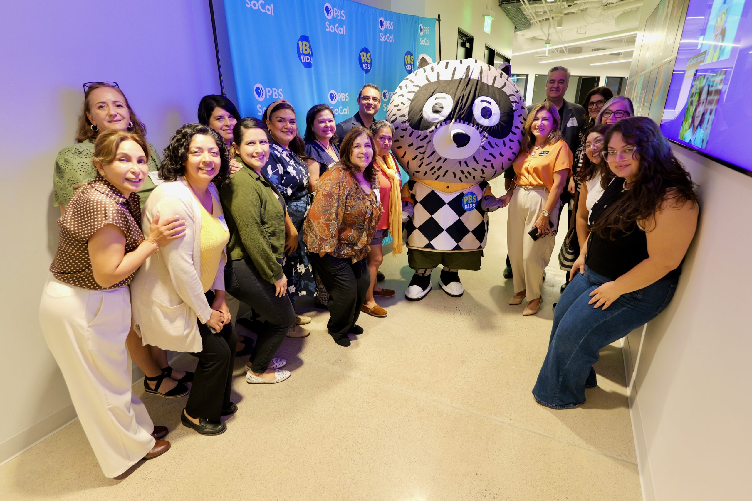 Attendees pose with Carl the Collector and OCDE Language Services Coordinator Natalia Abarca, in orange, during the department’s International Translation Day celebration at PBS SoCal studios in Costa Mesa.