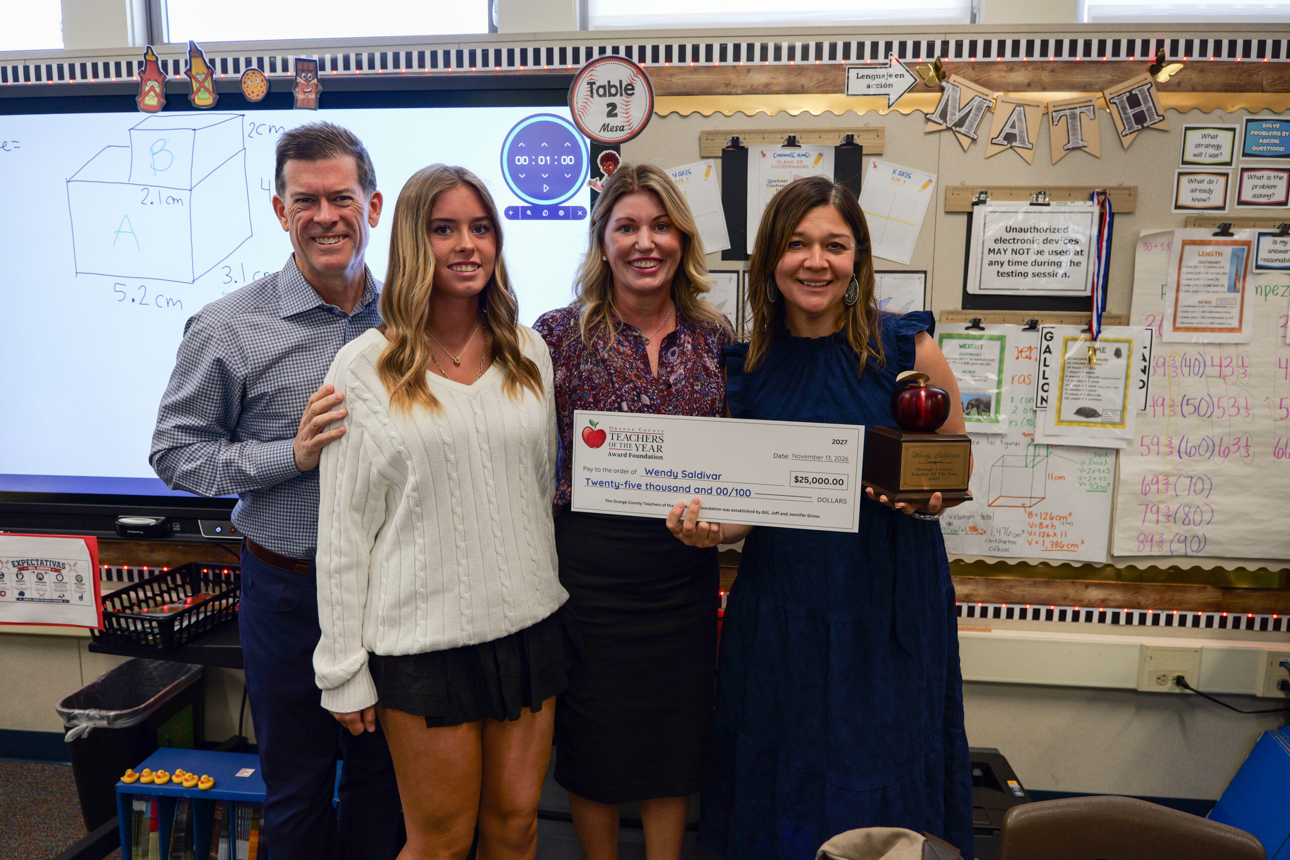 Wendy Saldivar, right, celebrates with members of the Gross family after receiving a $25,000 award from the Orange County Teachers of the Year Award Foundation during the April surprise announcement at Loara Elementary School.