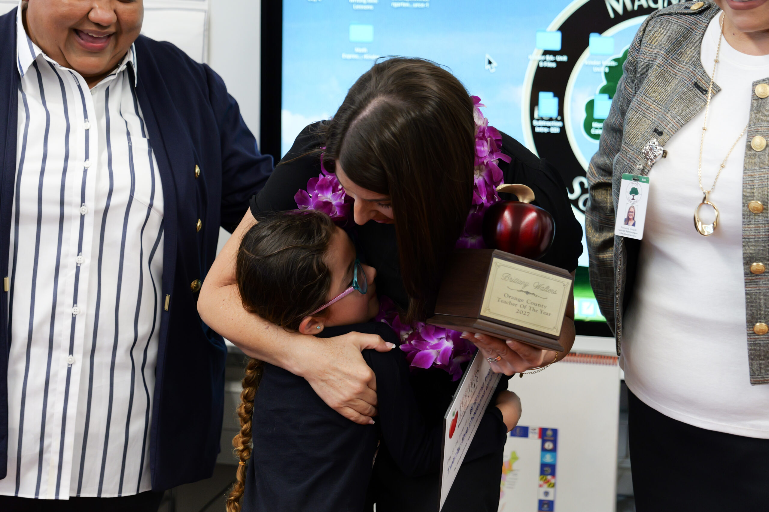Brittany Walters embraces one of her kindergarten students during a celebration of her selection as a 2027 Orange County Teacher of the Year at Dr. Peter Marshall Elementary School.