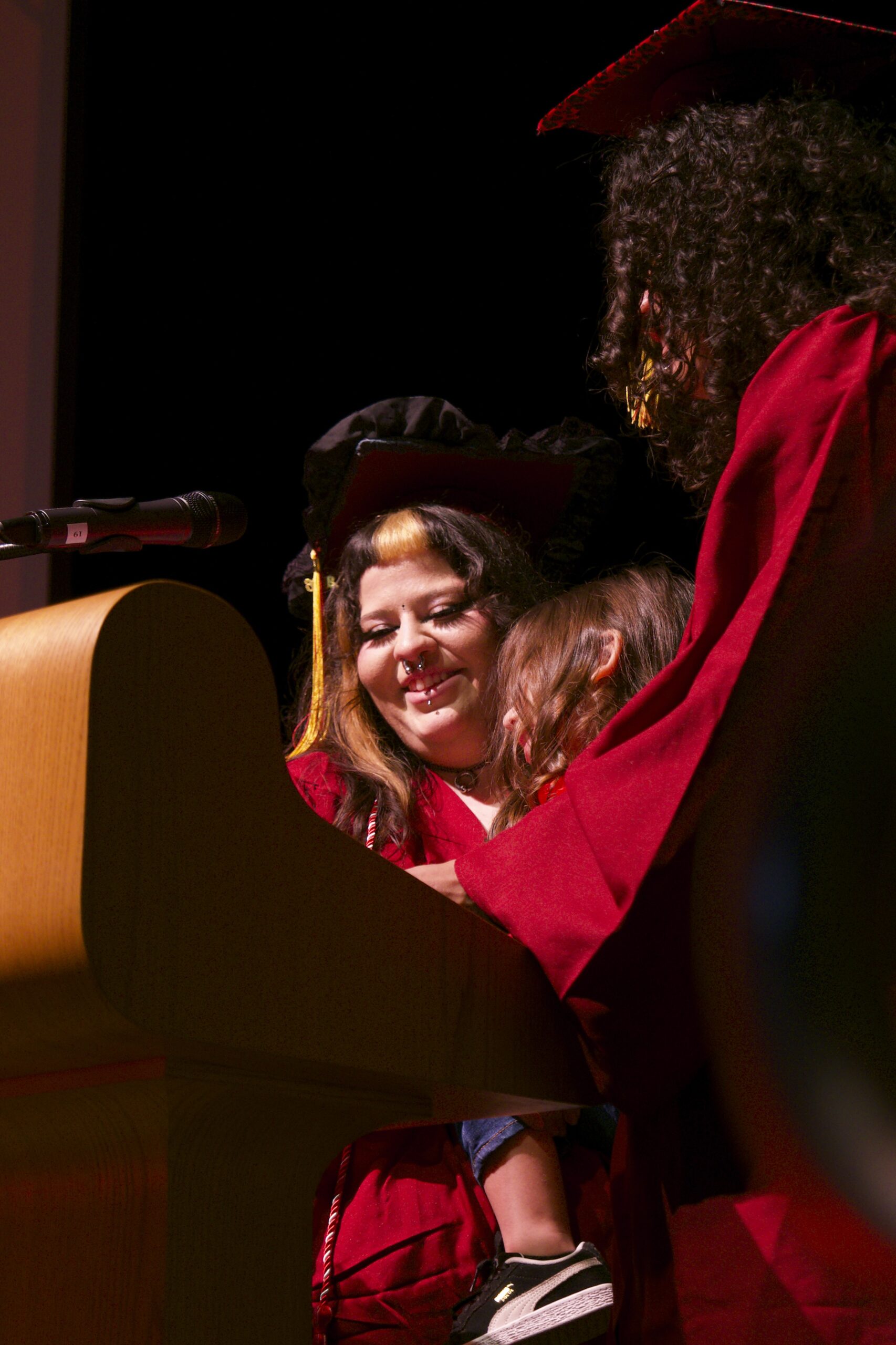 Two recent CCPA graduates share the stage with their son as they give speeches on completing the program and earning their diplomas at the June 16 ceremony. 