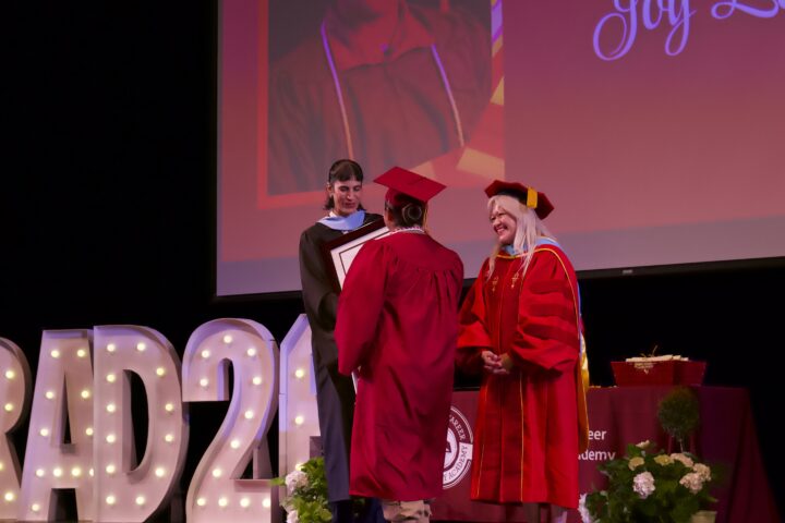 College and Career Preparatory Academy student Joy L. walks onto the stage to accept her Integrity Award at the June 16 graduation ceremony.