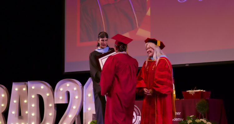College and Career Preparatory Academy student Joy L. walks onto the stage to accept her Integrity Award at the June 16 graduation ceremony.